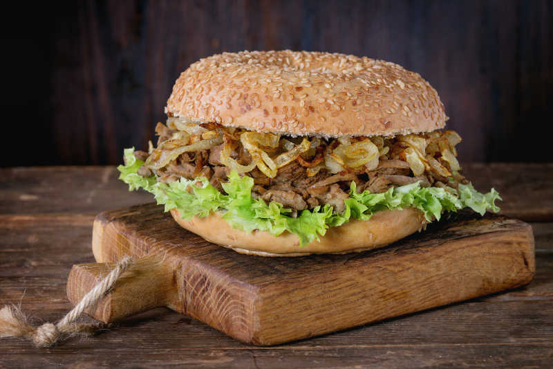 小木板上的百吉饼炖牛肉三明治