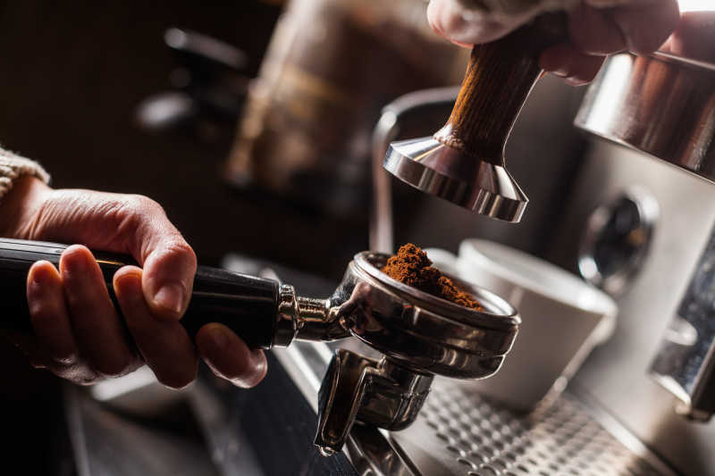操纵意大利浓咖啡制造机的咖啡师
