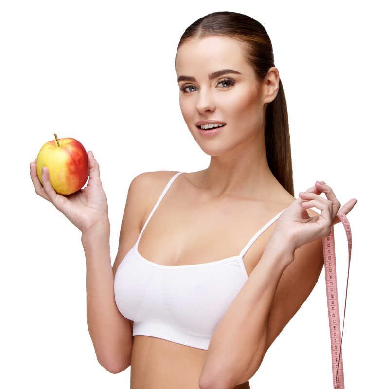 白色背景下拿着红苹果穿着吊带上衣的美女