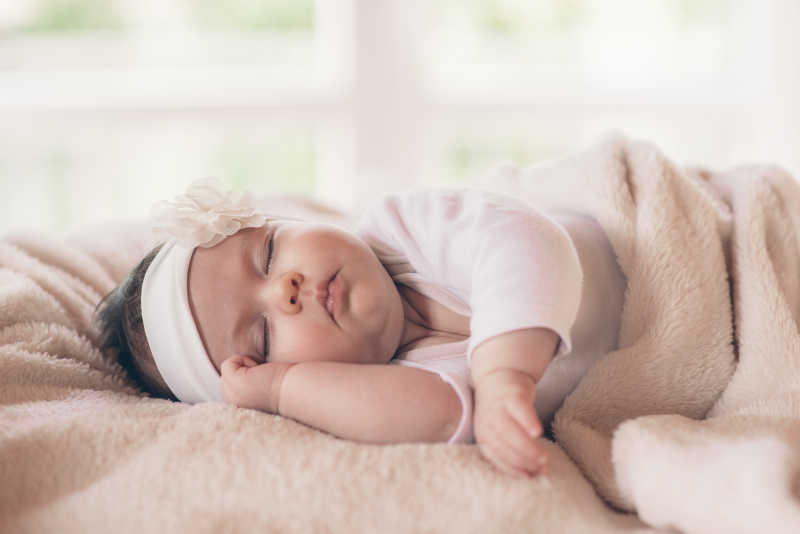 可爱装扮的睡在毛毯上的小宝宝