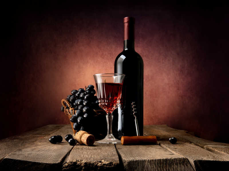 木制背景上的新鲜红酒和酒杯