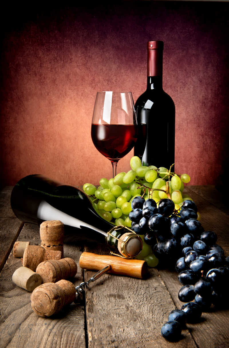 暗色背景上的红酒和葡萄