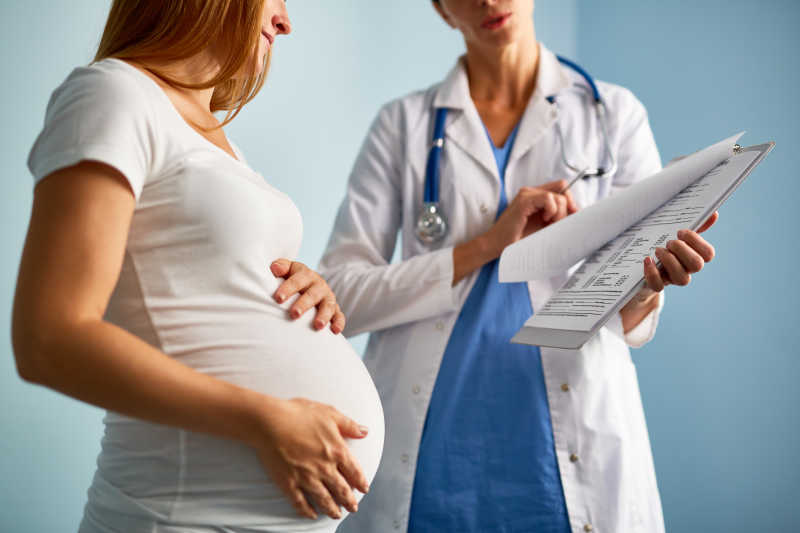 孕妇看着产科医生讲解孕检结果