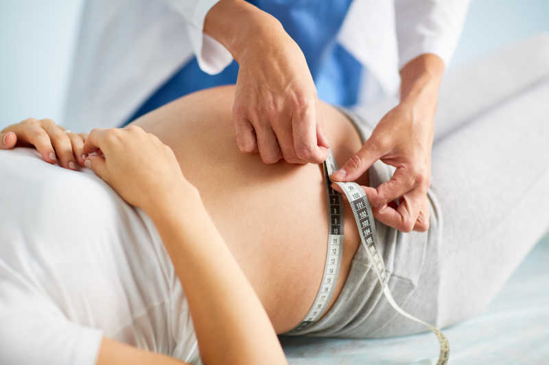 产科医生测量孕妇的腹部大小