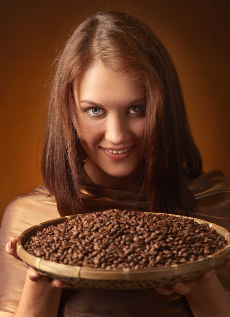 漂亮女人拿着烘焙的咖啡豆