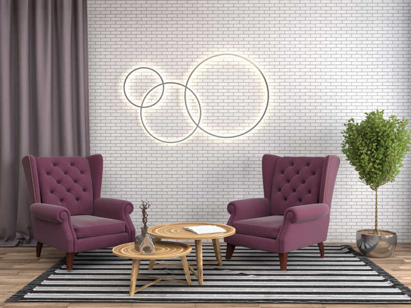 室内两个紫色扶手椅和木质茶几以及砖墙上的圆环装饰