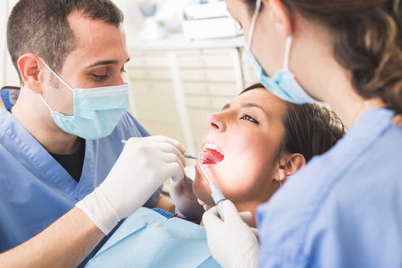 两个牙医检查美女牙齿