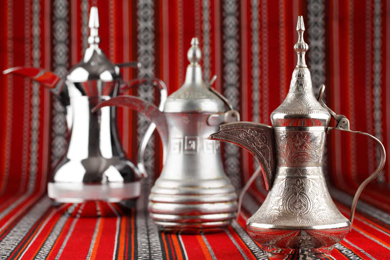 阿拉伯机织布上的三种精美的银制茶壶