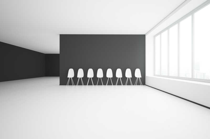 空荡的房间里黑色的墙壁和白色椅子