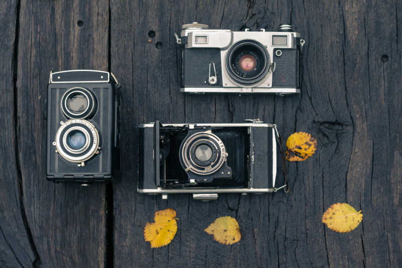 黑色木板上的三个复古相机