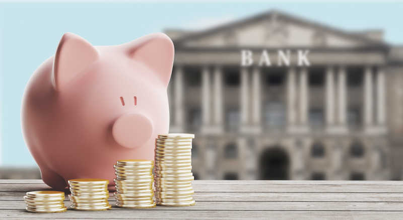 银行背景下的小猪存钱罐和硬币
