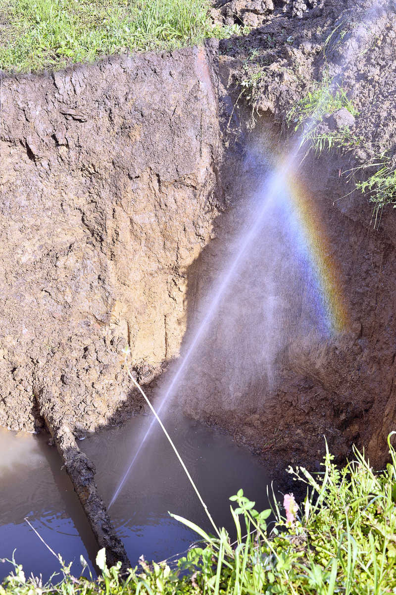 受损金属管道泄漏形式的水射流形成的彩虹