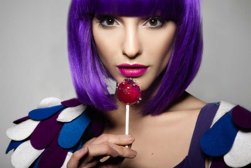 戴着紫色假发的吃棒棒糖的女孩