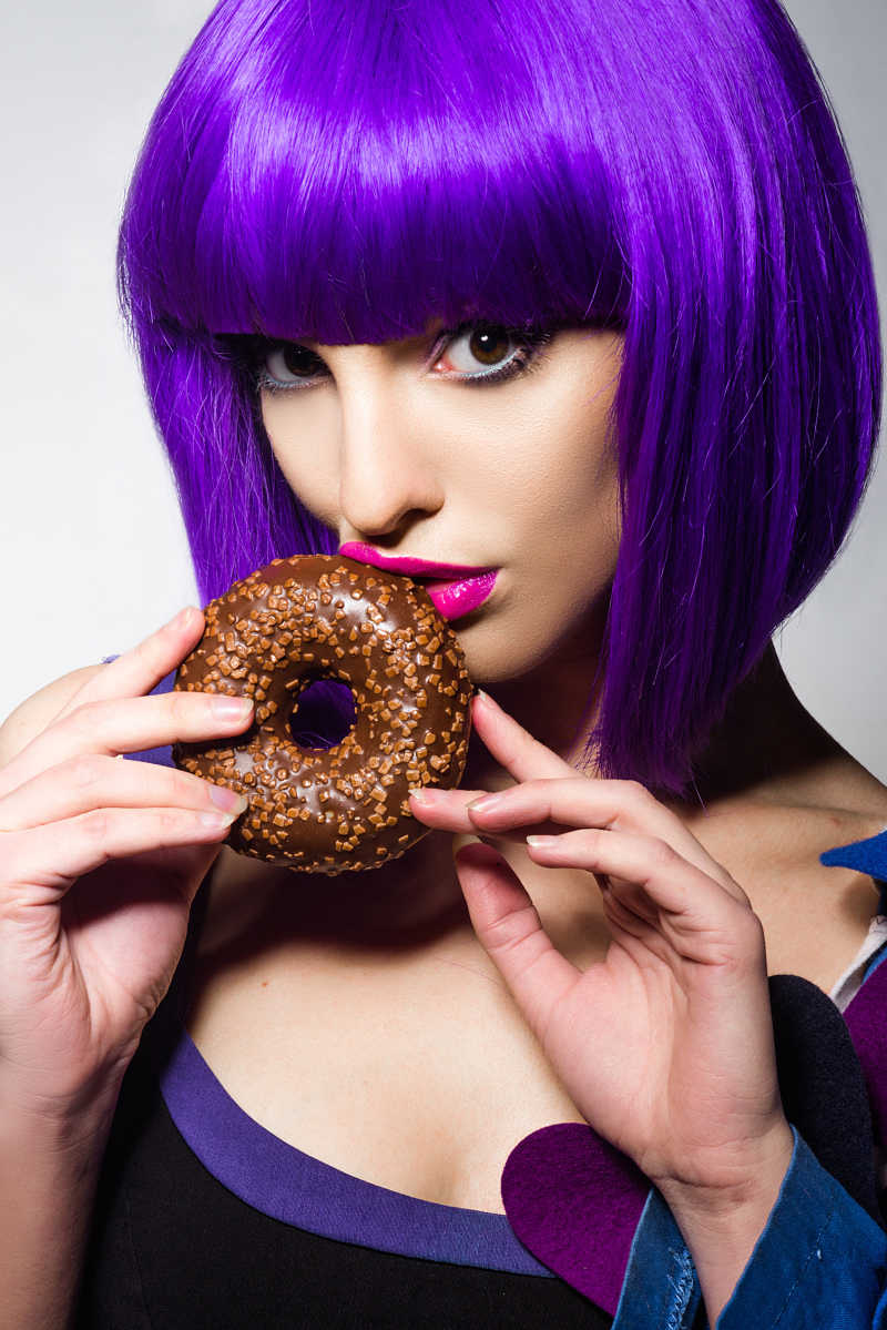 拿着甜甜圈一头紫色短发的女孩