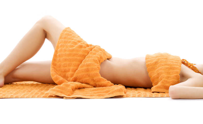 橙色毛巾下的年轻女人的身体