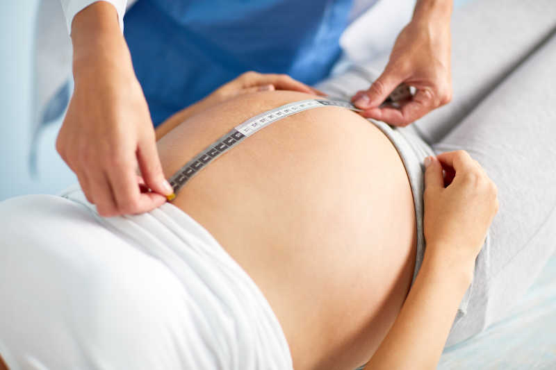医生为孕妇做腹部检查及测量