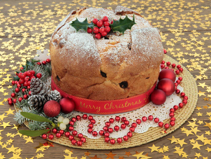 系着圣诞快乐缎带的蛋糕和黄金星星装饰