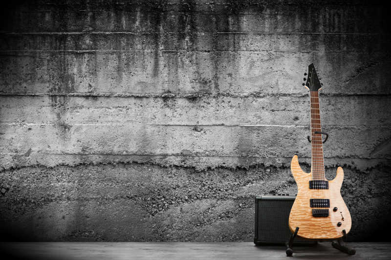 灰墙背景下的木吉他