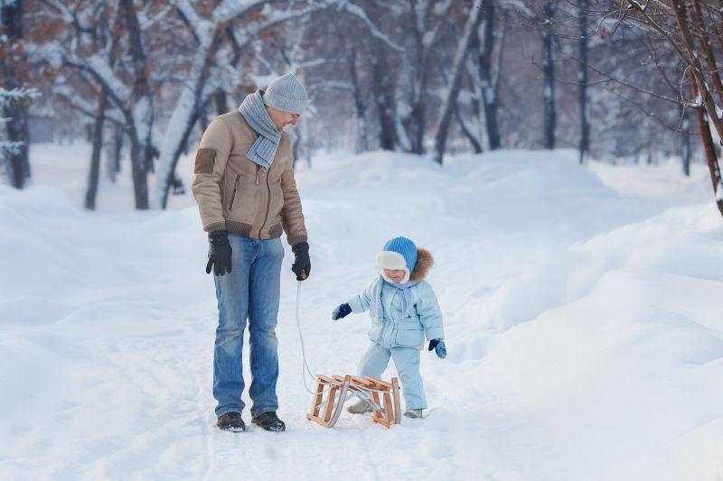 雪地里父亲带着孩子玩雪