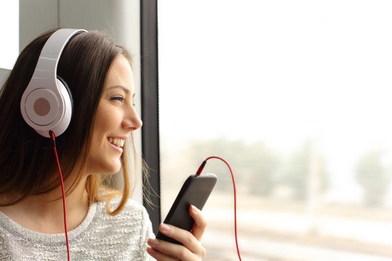 在火车上带着耳机听音乐的女孩