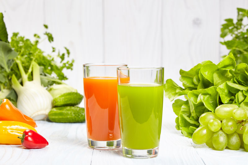 白色木板上的健康蔬菜水果汁与蔬菜水果