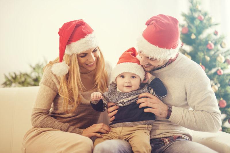 外国夫妇抱着戴圣诞帽的小孩子