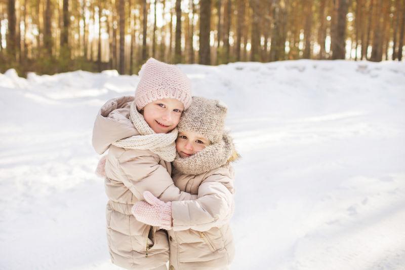 雪地里互相拥抱着的两个小女孩