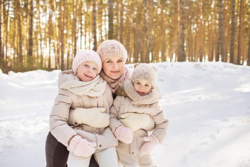 雪地里母亲抱着两个小女儿