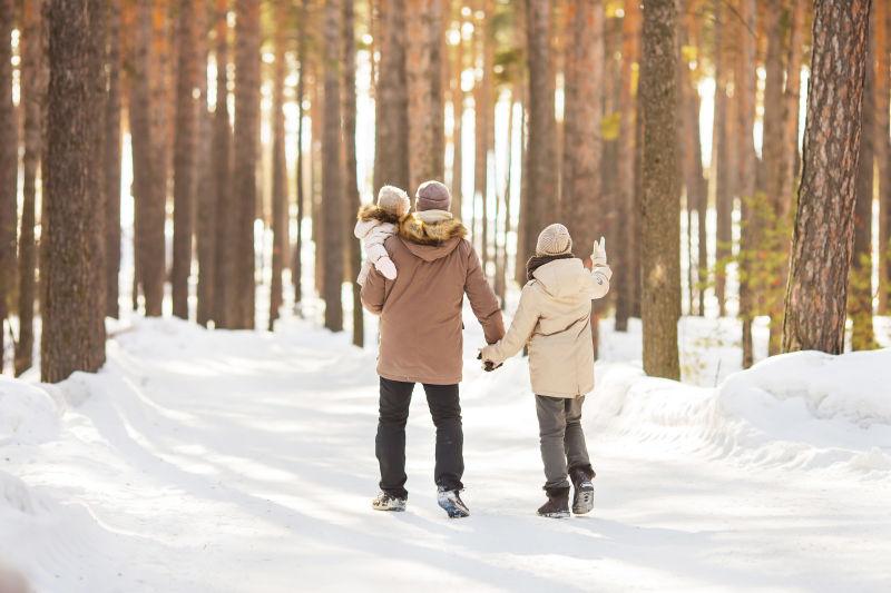 冬季在森林里散步的一家人
