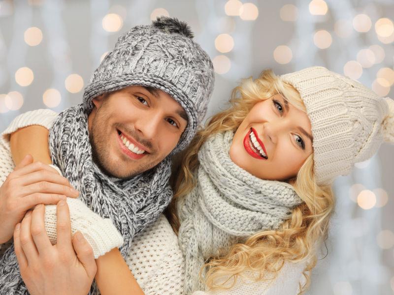 圣诞节戴着帽子的情侣开心的依偎在一起