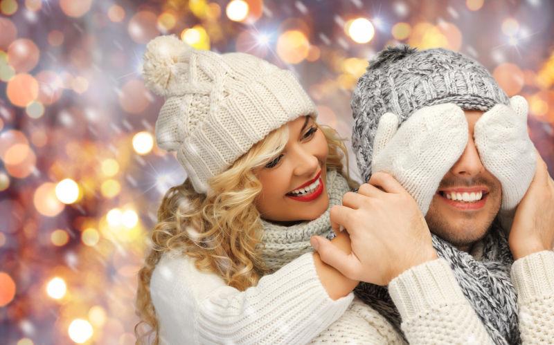 圣诞节夜景背景下快乐的夫妻俩穿冬装开心的玩