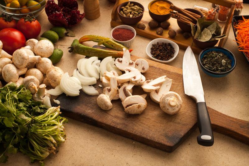 在木板上切蘑菇和烹调所需要使用的原料