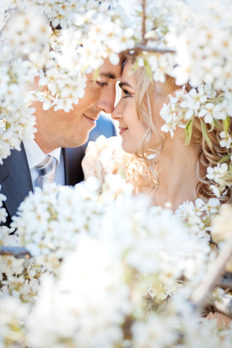 纯洁的花朵旁亲吻的夫妇