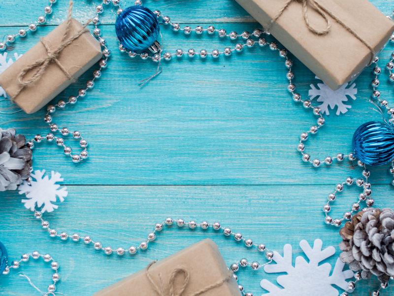 蓝色条纹桌上的牛皮纸礼盒和圣诞装饰品
