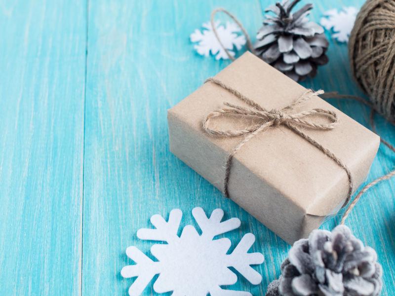 蓝色木板上的牛皮纸礼物和圣诞装饰品
