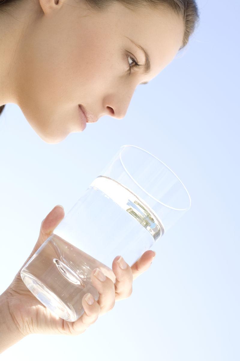 一个年轻女子拿着杯水在户外