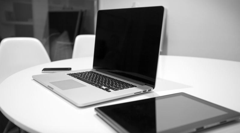 白色桌子上的笔记本电脑和平板