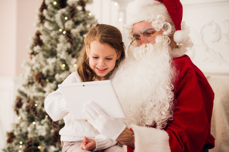 圣诞树旁边的圣诞老人将女孩抱在了怀里