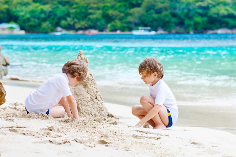 在沙滩上建造沙子城堡的两个孩子