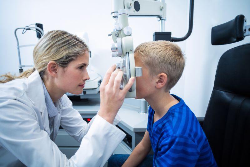 女性验光师对年轻患者眼镜进行检查