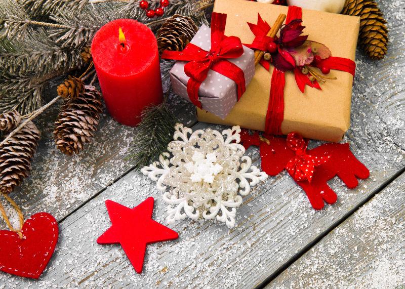 木制圣诞装饰的红色蜡烛和礼盒