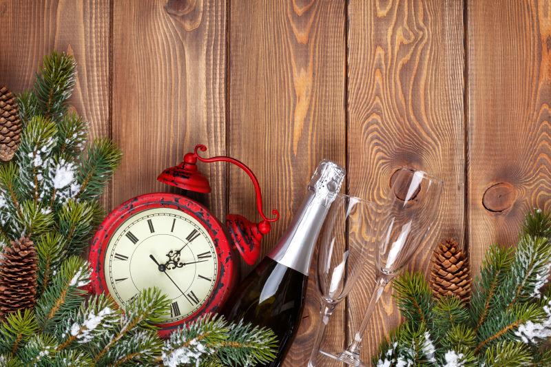圣诞节木背景的钟与杉树和香槟