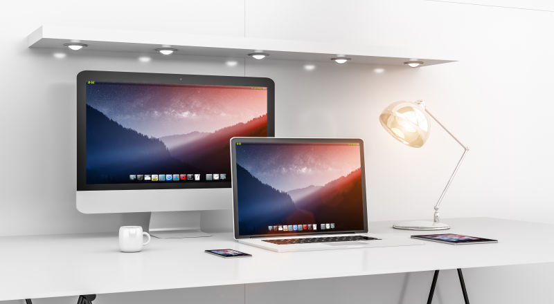 白色办公桌上Mac电脑和MacBook