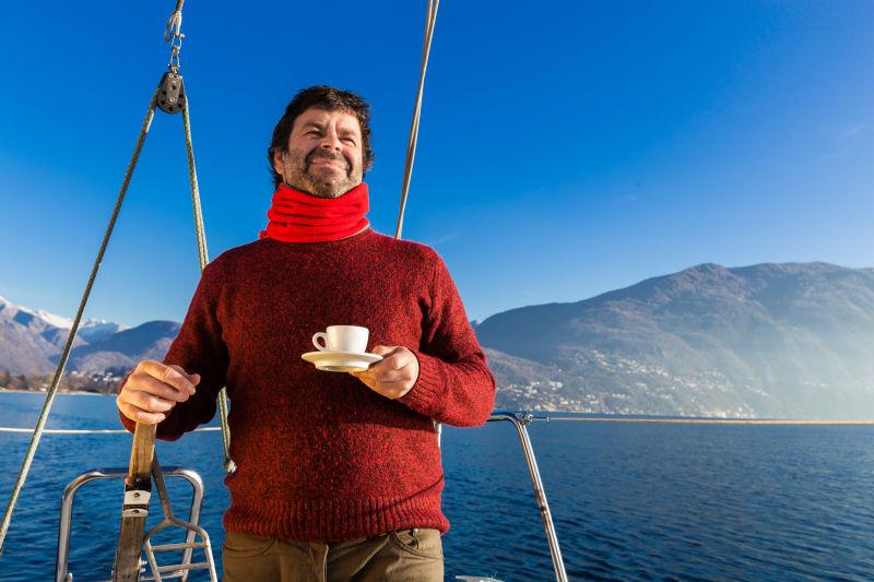 帆船上喝咖啡的男人