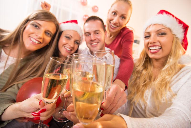 用香槟和祝酒来庆祝圣诞节的朋友们