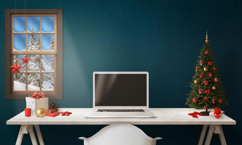 白色笔记本电脑桌上的圣诞树和礼品