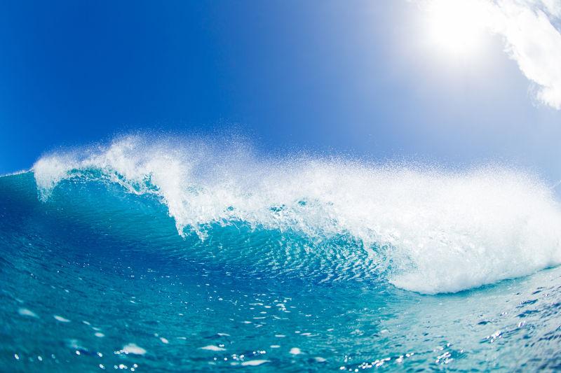 蓝天有阳光的背景下翻滚的蓝色海浪