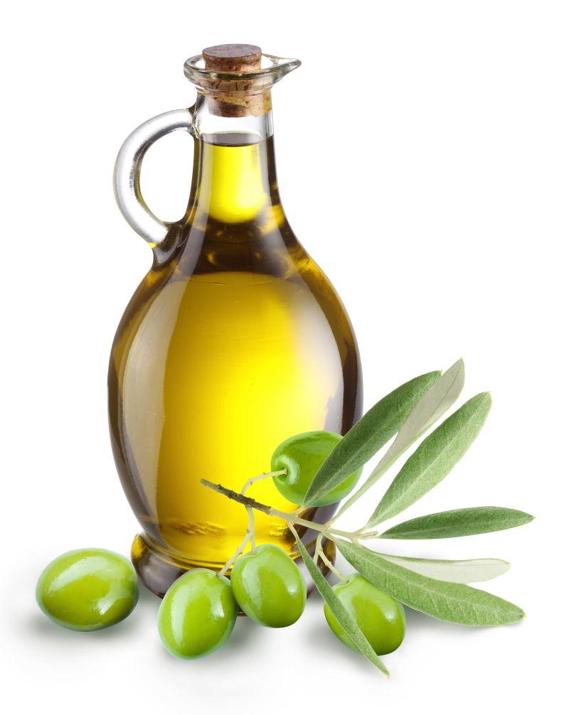 白色背景下一瓶满满的橄榄油和带着枝叶的橄榄