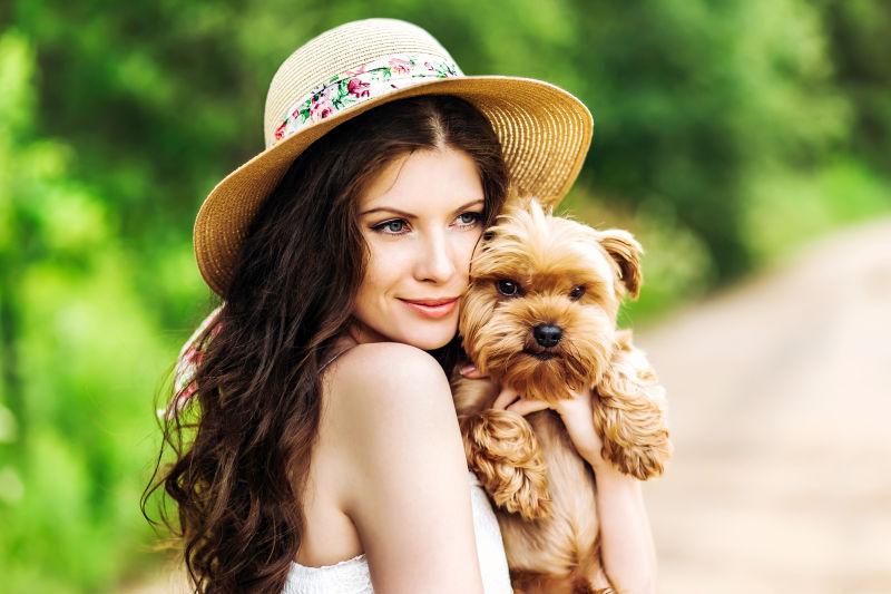 戴帽子的长发美女抱着可爱的狗狗