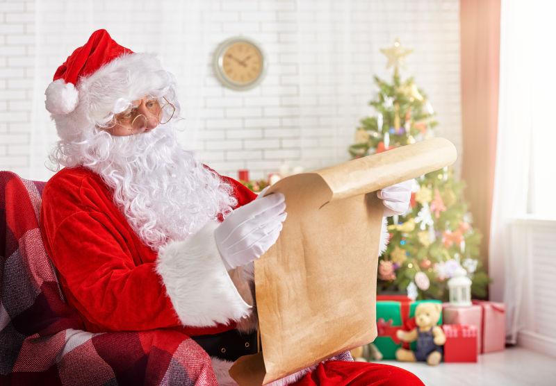 圣诞老人坐在有很多礼物圣诞树旁边